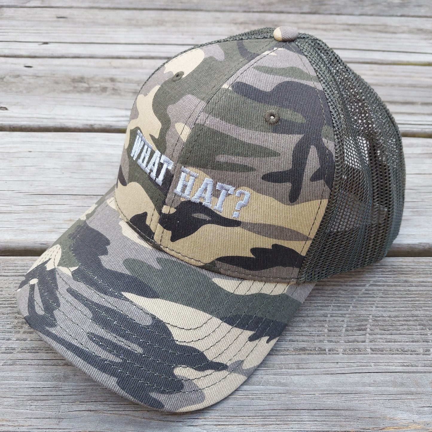 What Hat? embroidered on camo mesh trucker hat, angle view