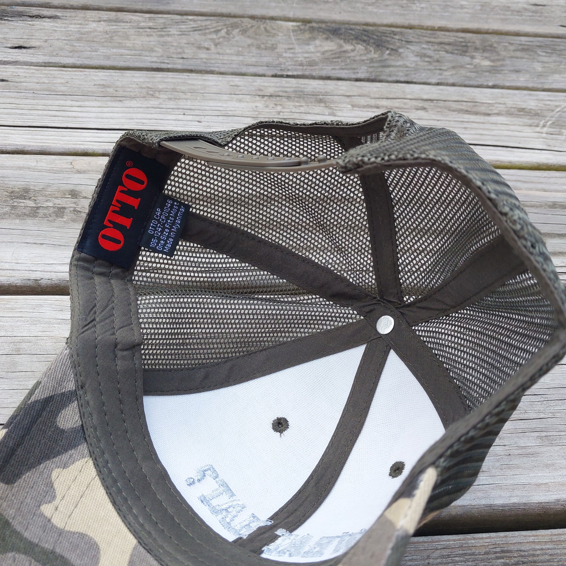 What Hat? embroidered on camo mesh trucker hat, under view